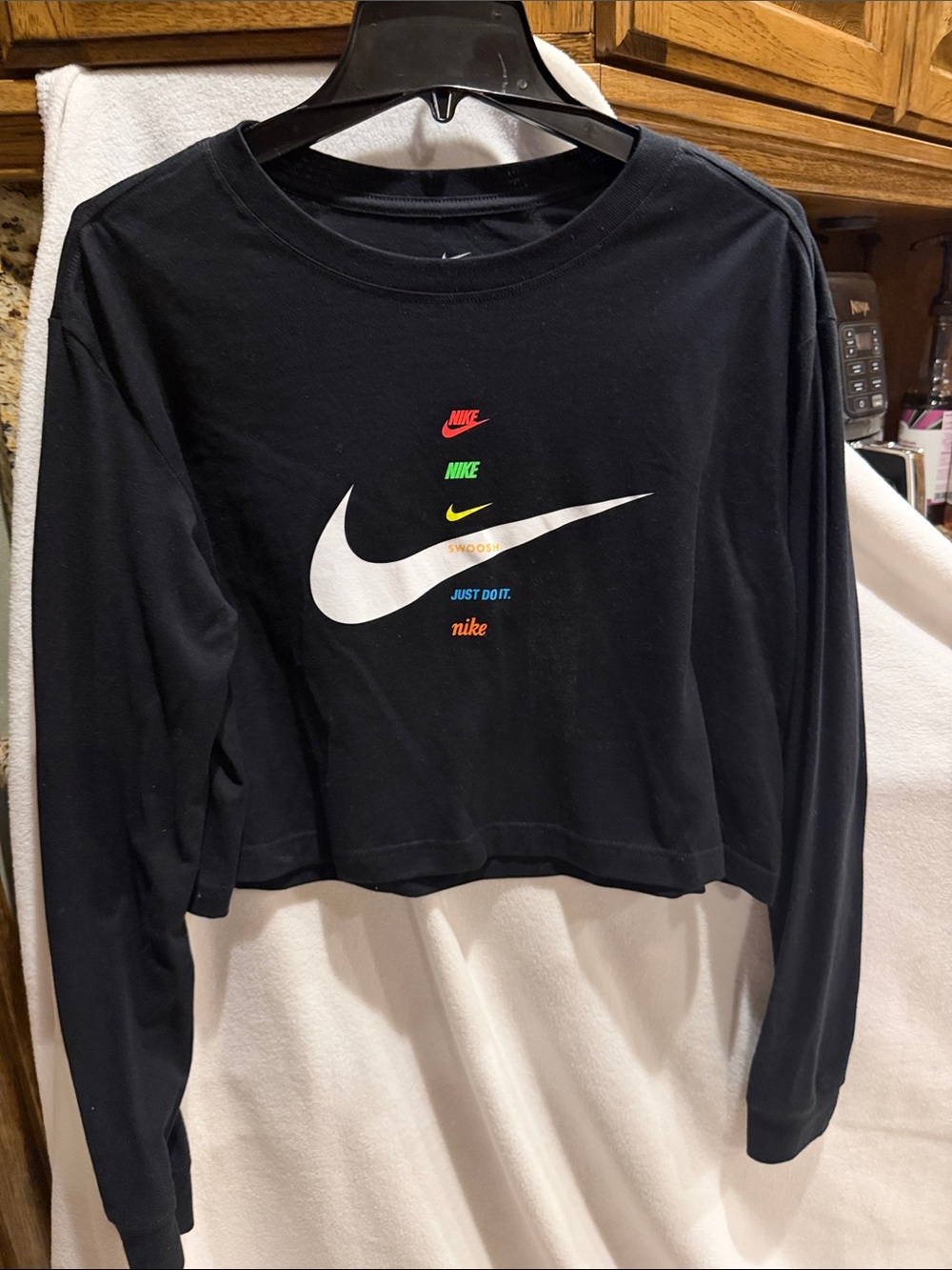 Nike Black Cropped Long-Sleeve Tee with White Swoosh and Multi-Color Logos